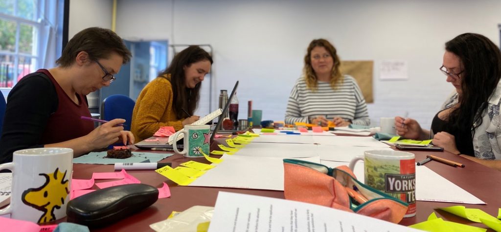 Four members of our Grants team sitting around a table planning.