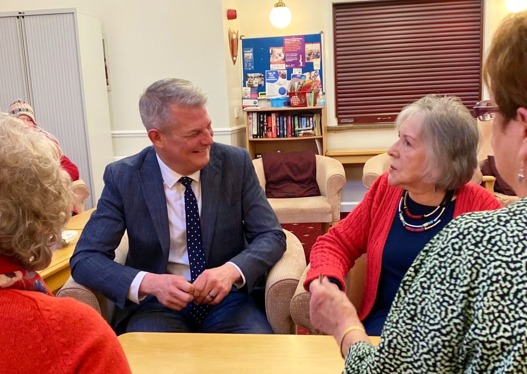 Minister with a service user in red