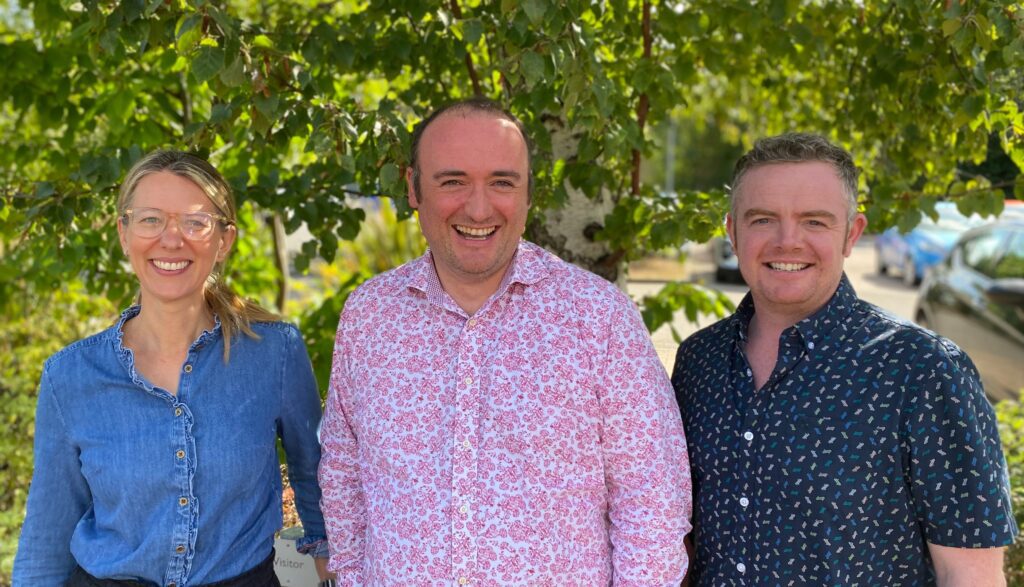 three people in front of a tree